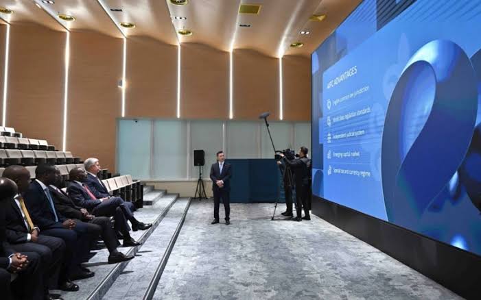 A briefing in an AIFC auditorium with AIFC advantages on screen