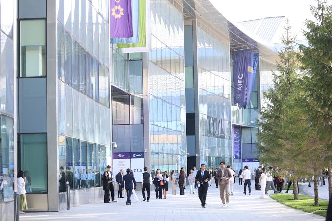 The AIFC campus walkway with participants and AIFC banners